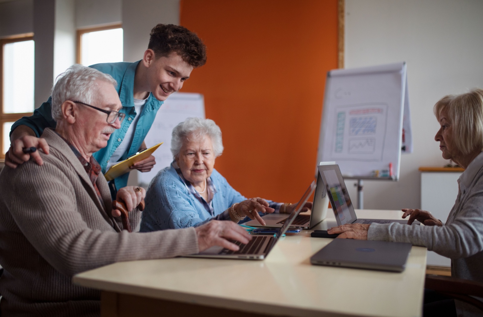 3 older adult attend a computer skills class through their senior living community.